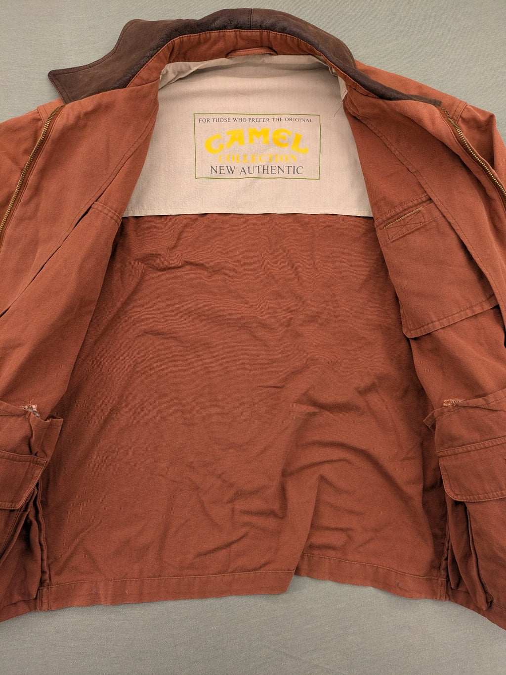 Camel Collection brown jacket with orange contrast collar and embroidered logo.
