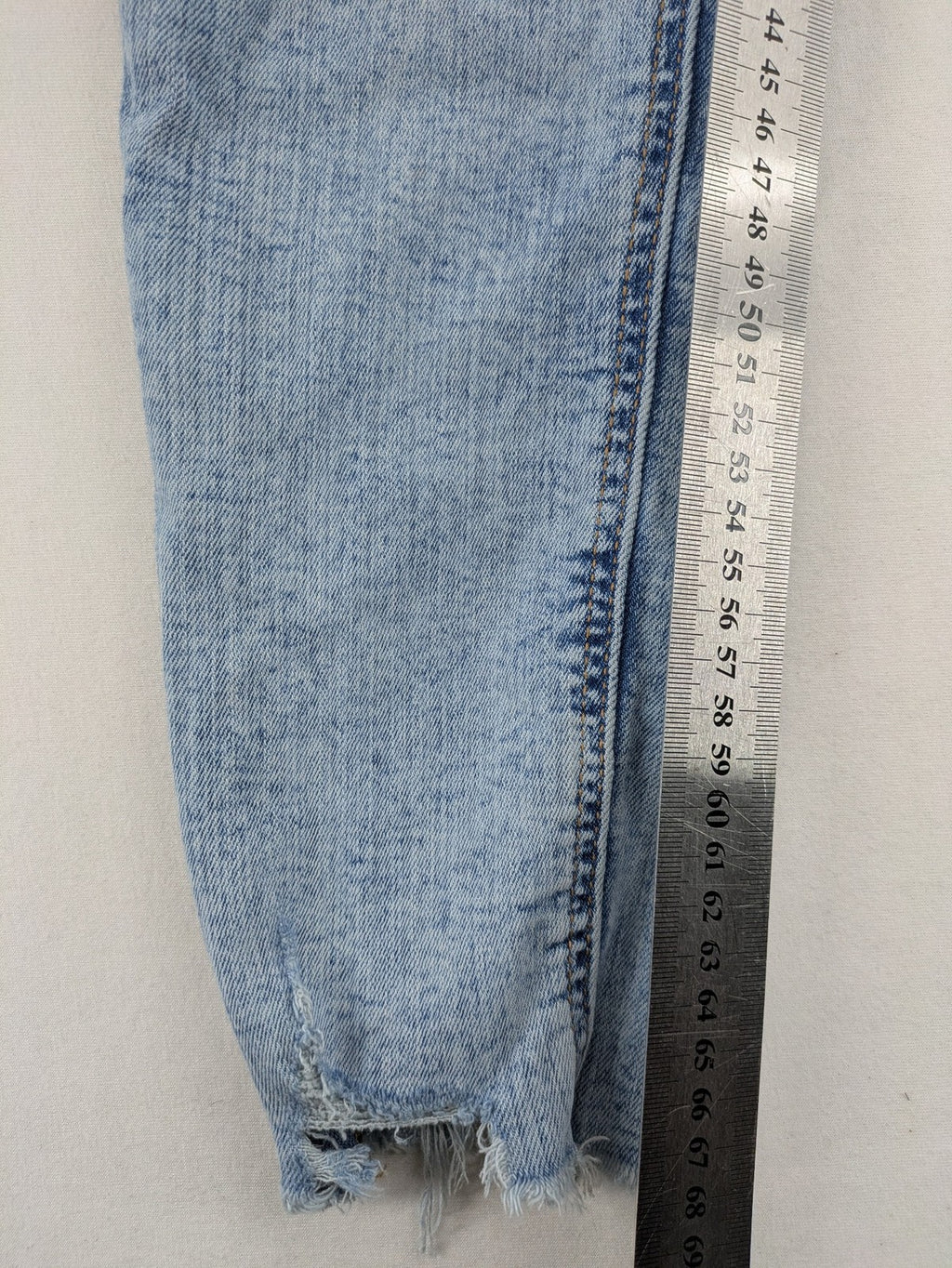 Clockhouse blue skinny jeans with distressed details and frayed hem, mid-rise fit.