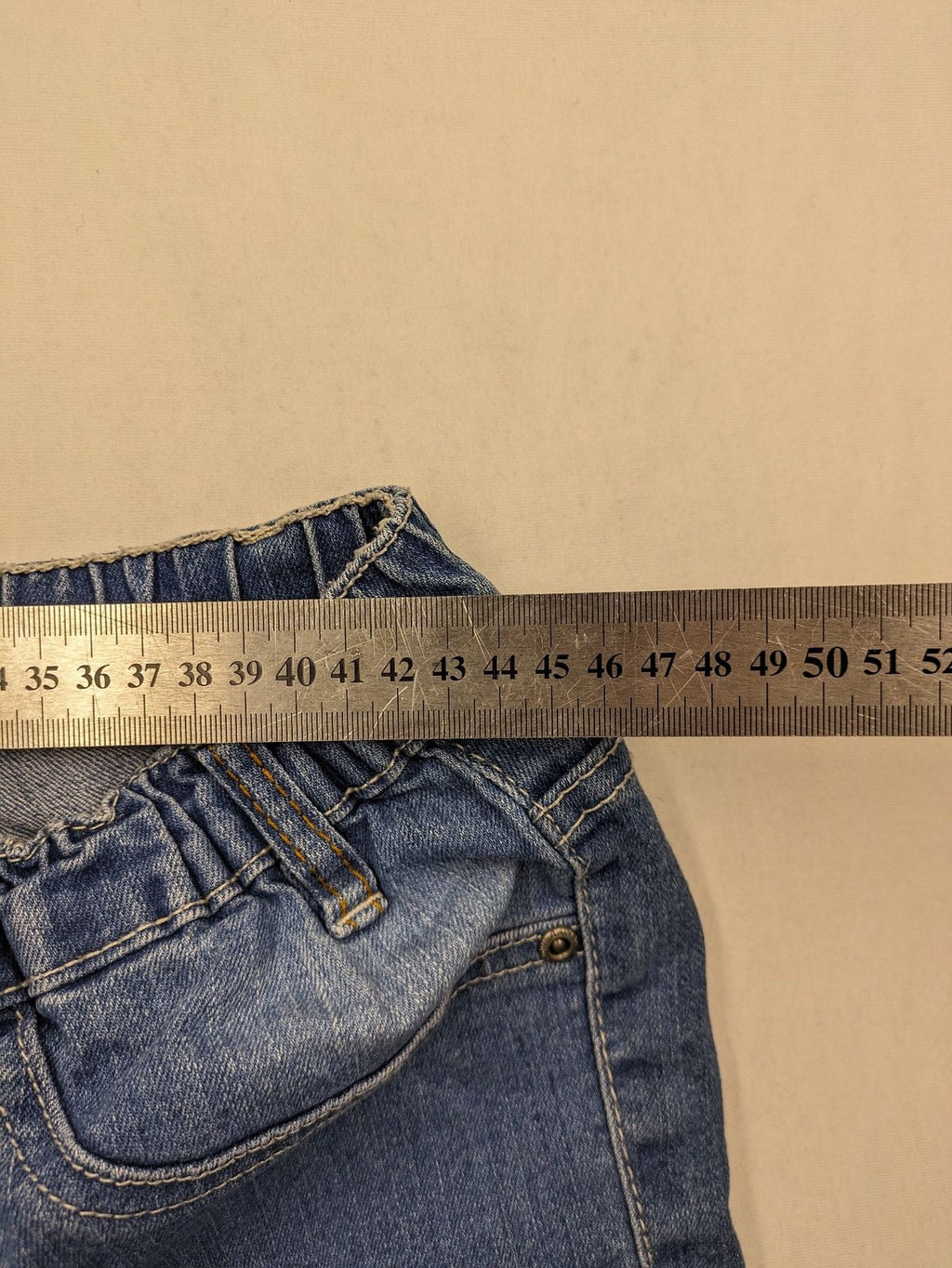 Rainbow blue straight jeans with elastic waistband and decorative knee stitching.