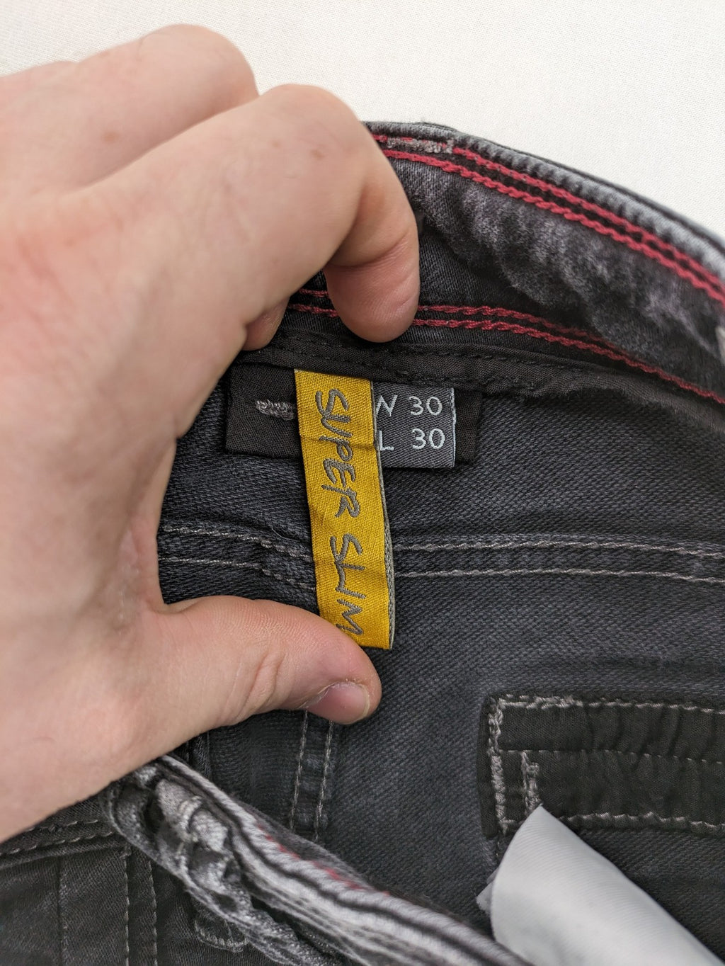 Tom Tompson grey slim tapered jeans with washed denim finish and subtle branding.