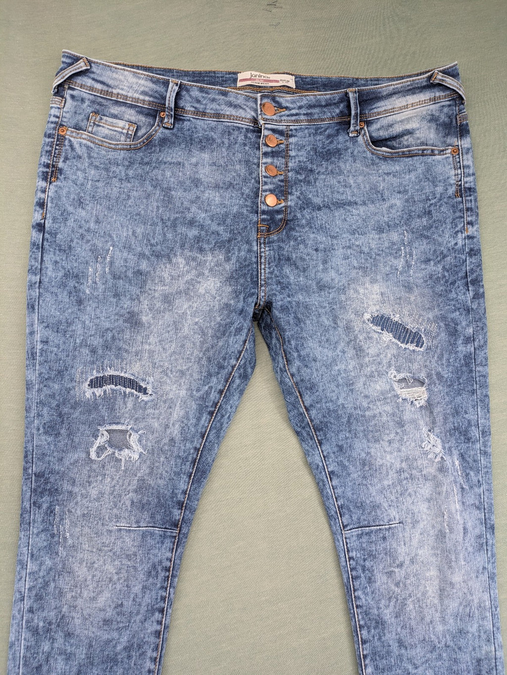 Janina blue slim fit jeans with acid wash, destroyed details, and button fly.