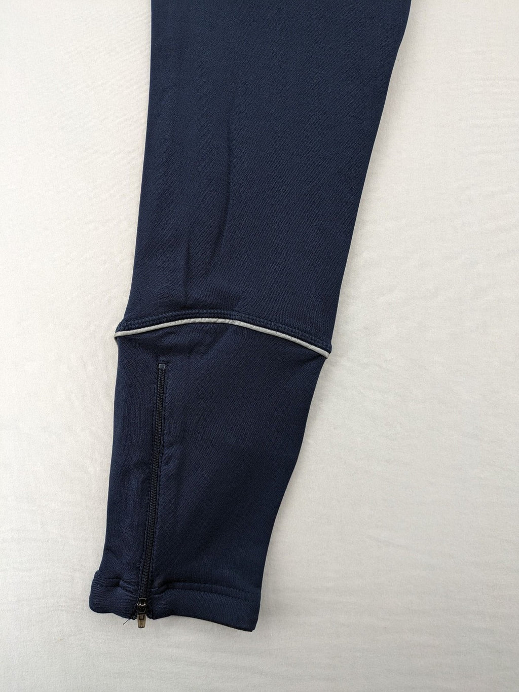 Crane Sports navy running tights with reflective details and zippered ankle openings.