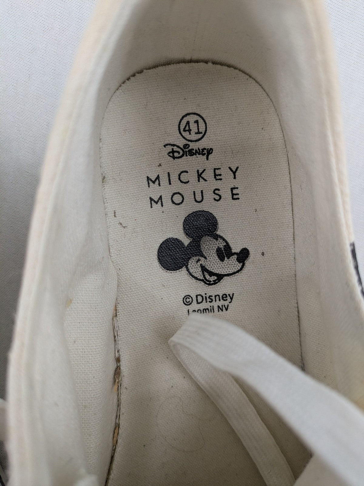 Disney Mickey Mouse white canvas low top sneakers with iconic Mickey Mouse graphic.