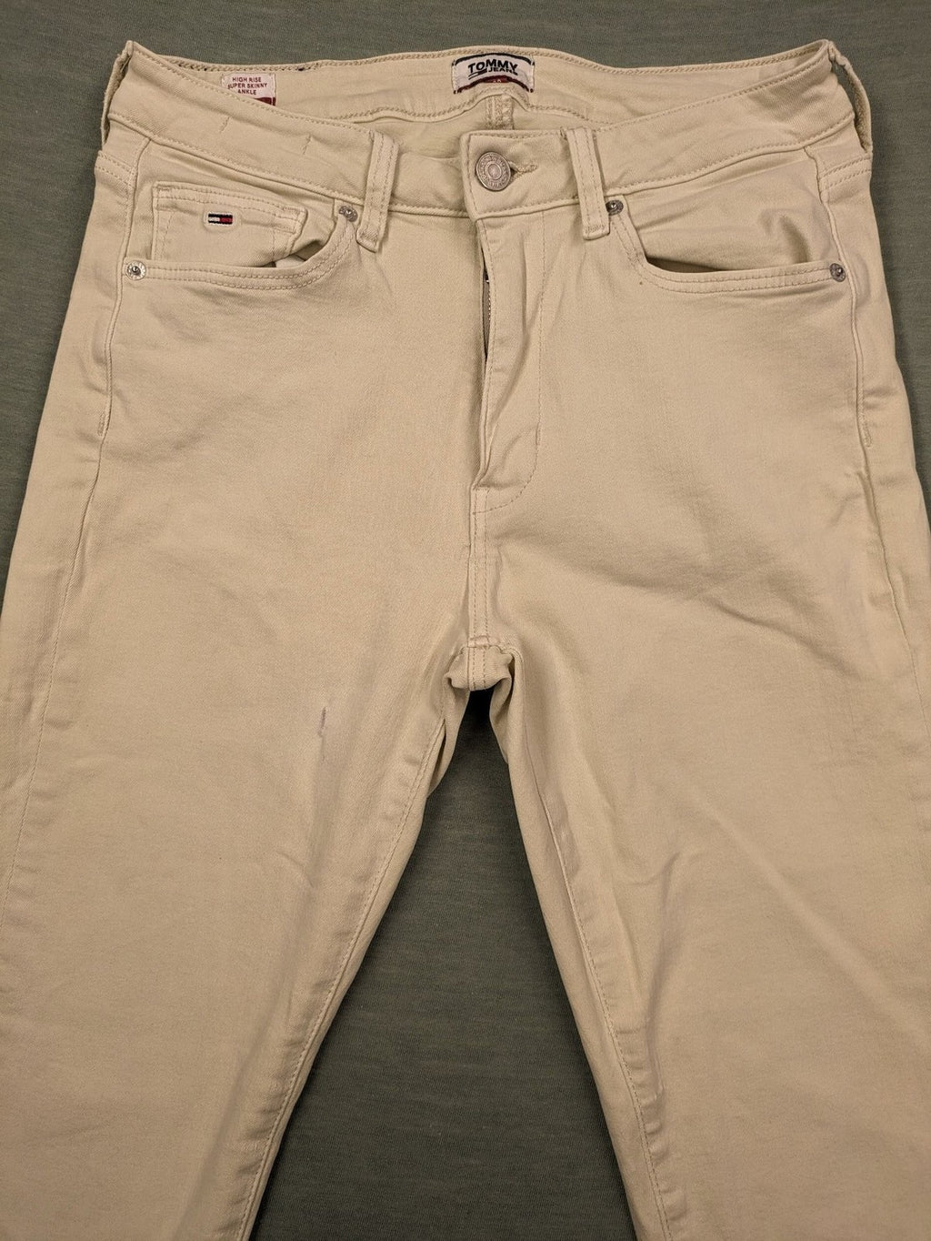 Tommy Jeans beige high rise skinny ankle jeans with logo patch and stretch fabric.