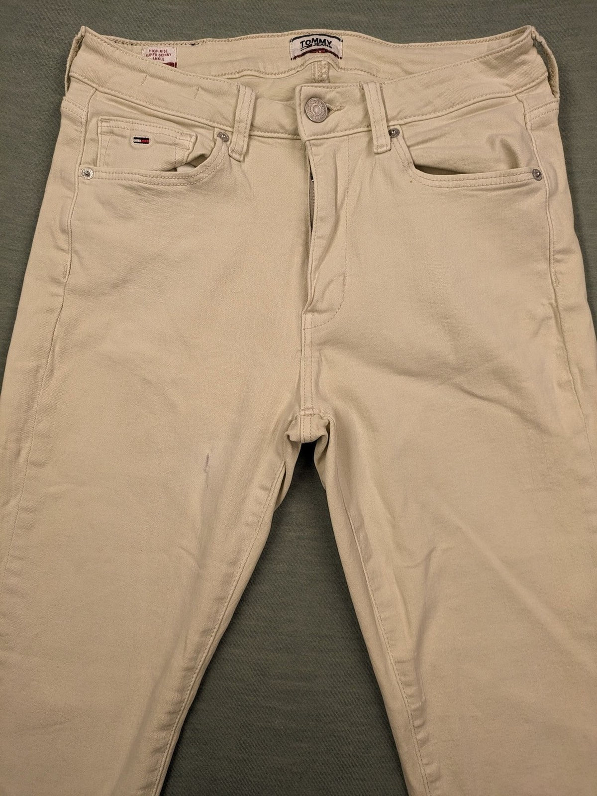 Tommy Jeans beige high rise skinny ankle jeans with logo patch and stretch fabric.