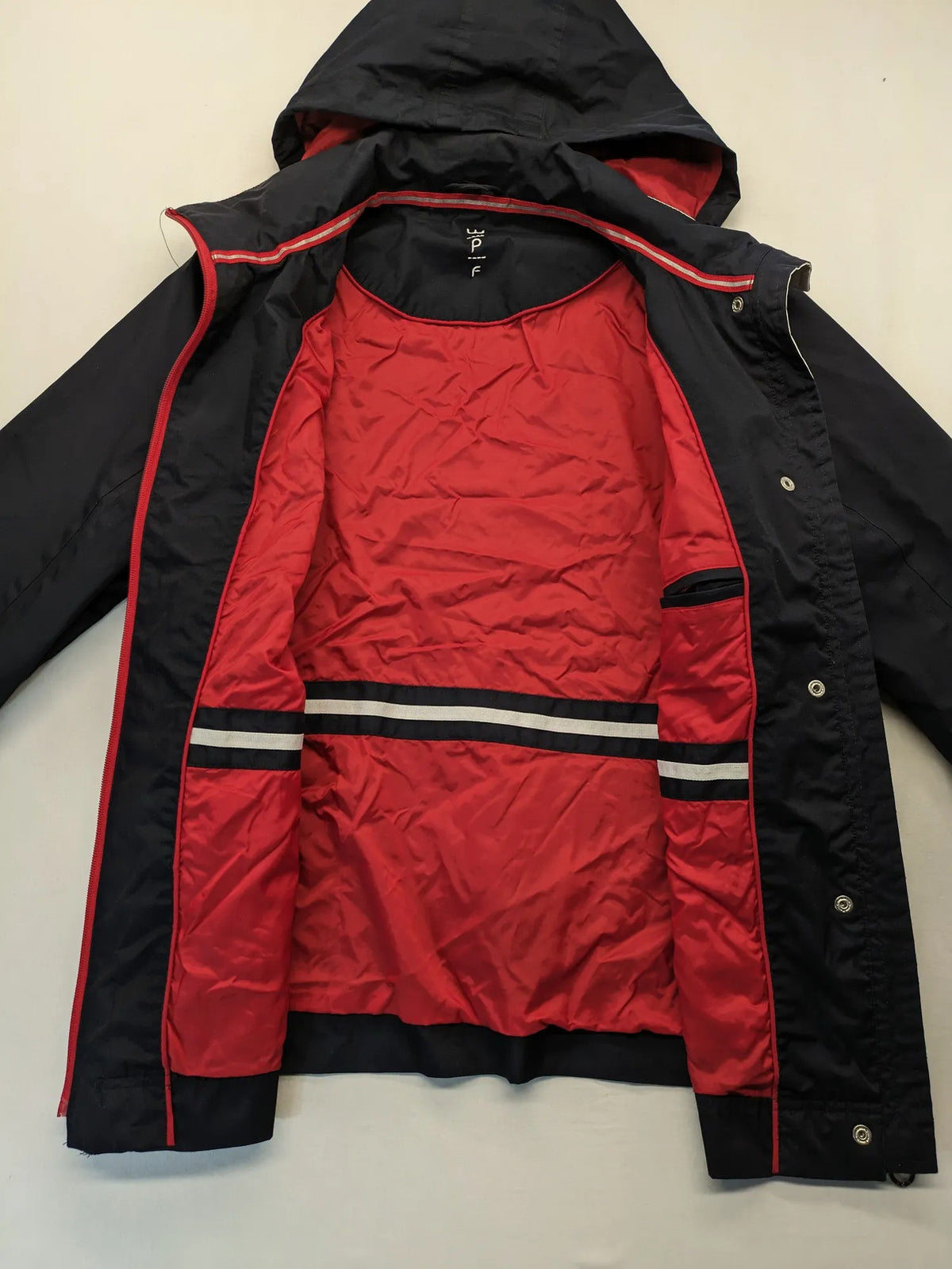 WPF grey outdoor jacket with red lining, zip closure, and hood.