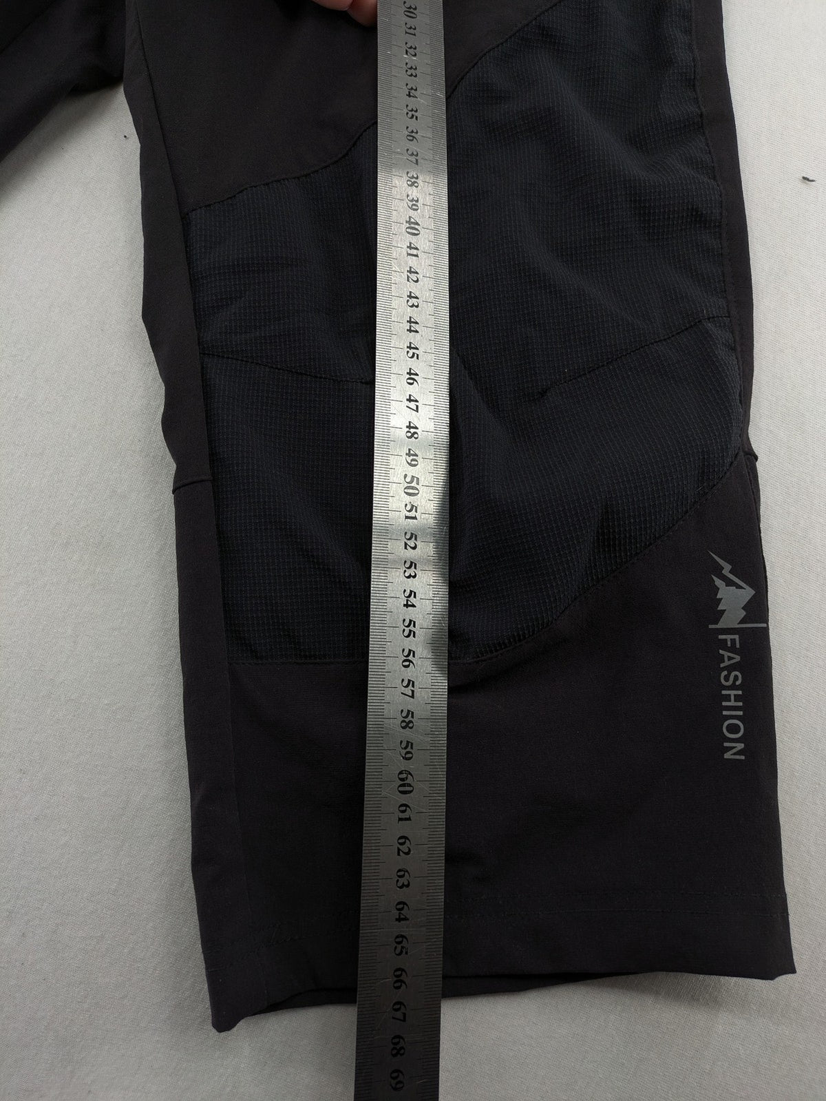 Outdoor black capri pants with elastic waistband and multiple zippered pockets.
