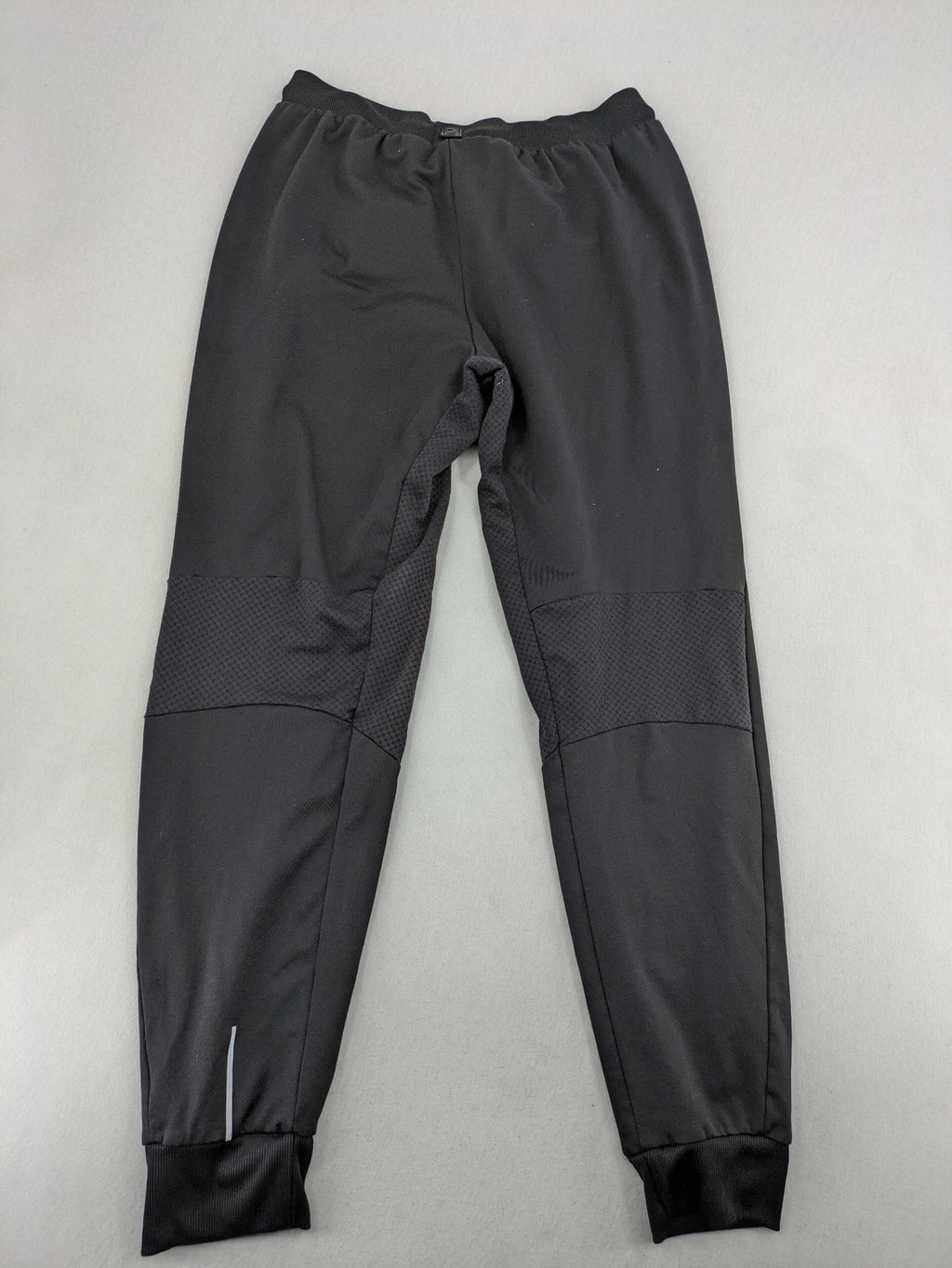 Kalenji black loungewear pants with grey accents and zippered side pockets.
