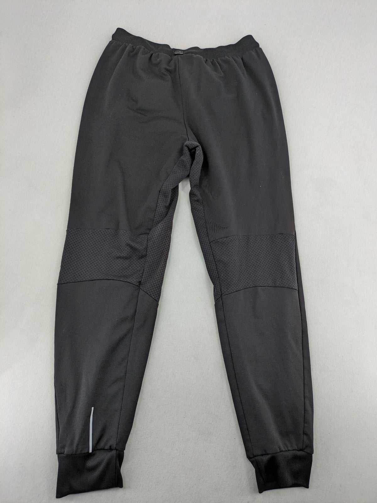 Kalenji black loungewear pants with grey accents and zippered side pockets.