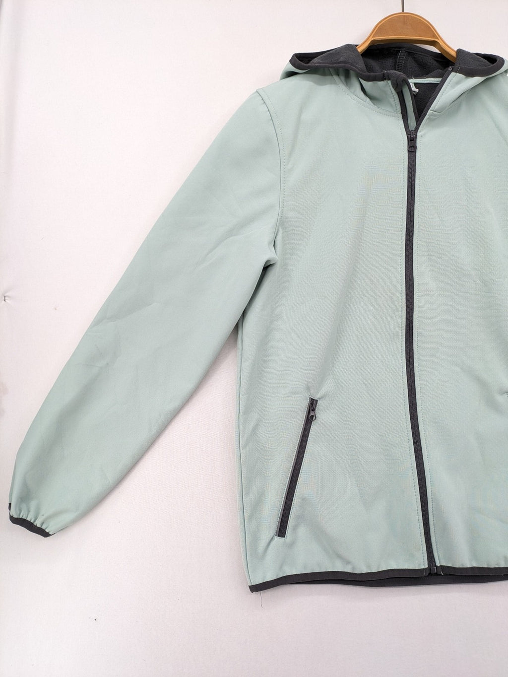 YFK outdoor jacket mint green softshell with dark grey fleece lining and hood.