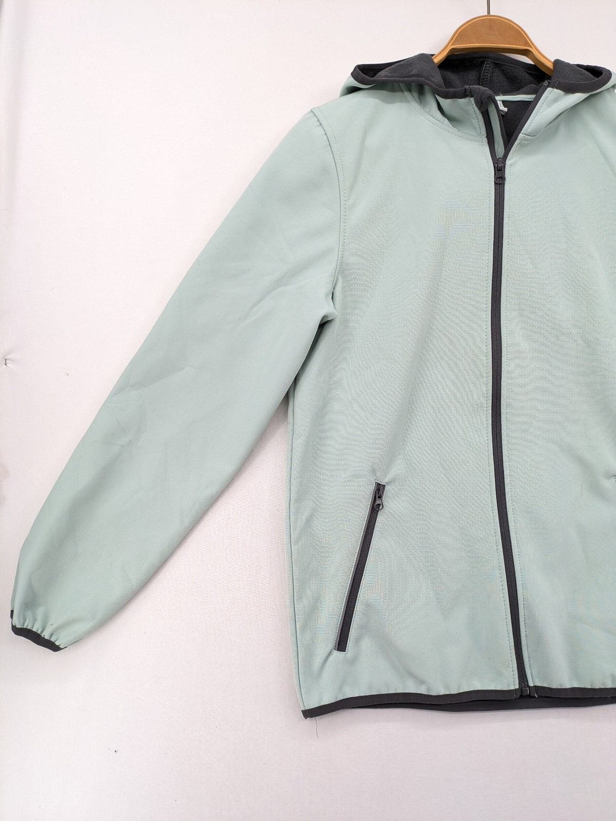 YFK outdoor jacket mint green softshell with dark grey fleece lining and hood.