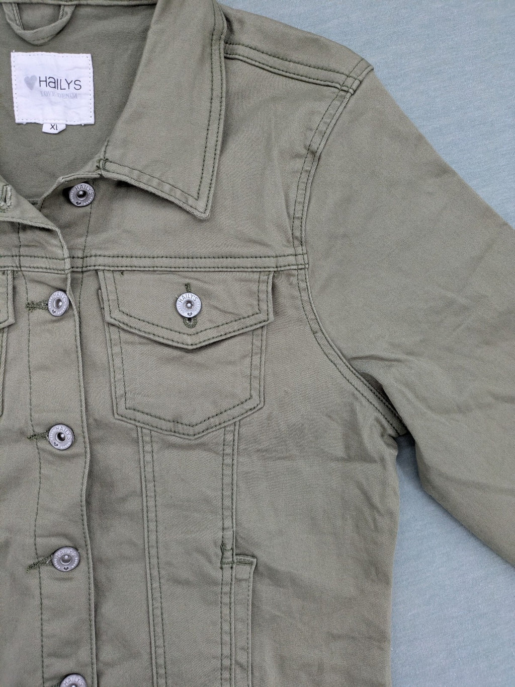 Hailys khaki denim jacket with button closure, two chest pockets, and side pockets.