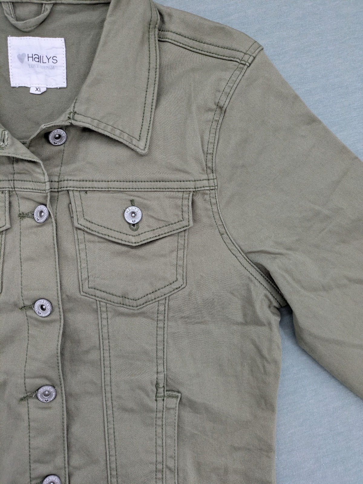 Hailys khaki denim jacket with button closure, two chest pockets, and side pockets.