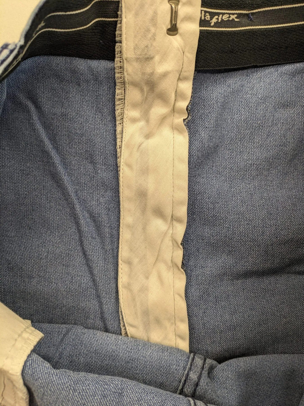 REI blue straight jeans with front pleats, zip fly, and buttoned back pockets.