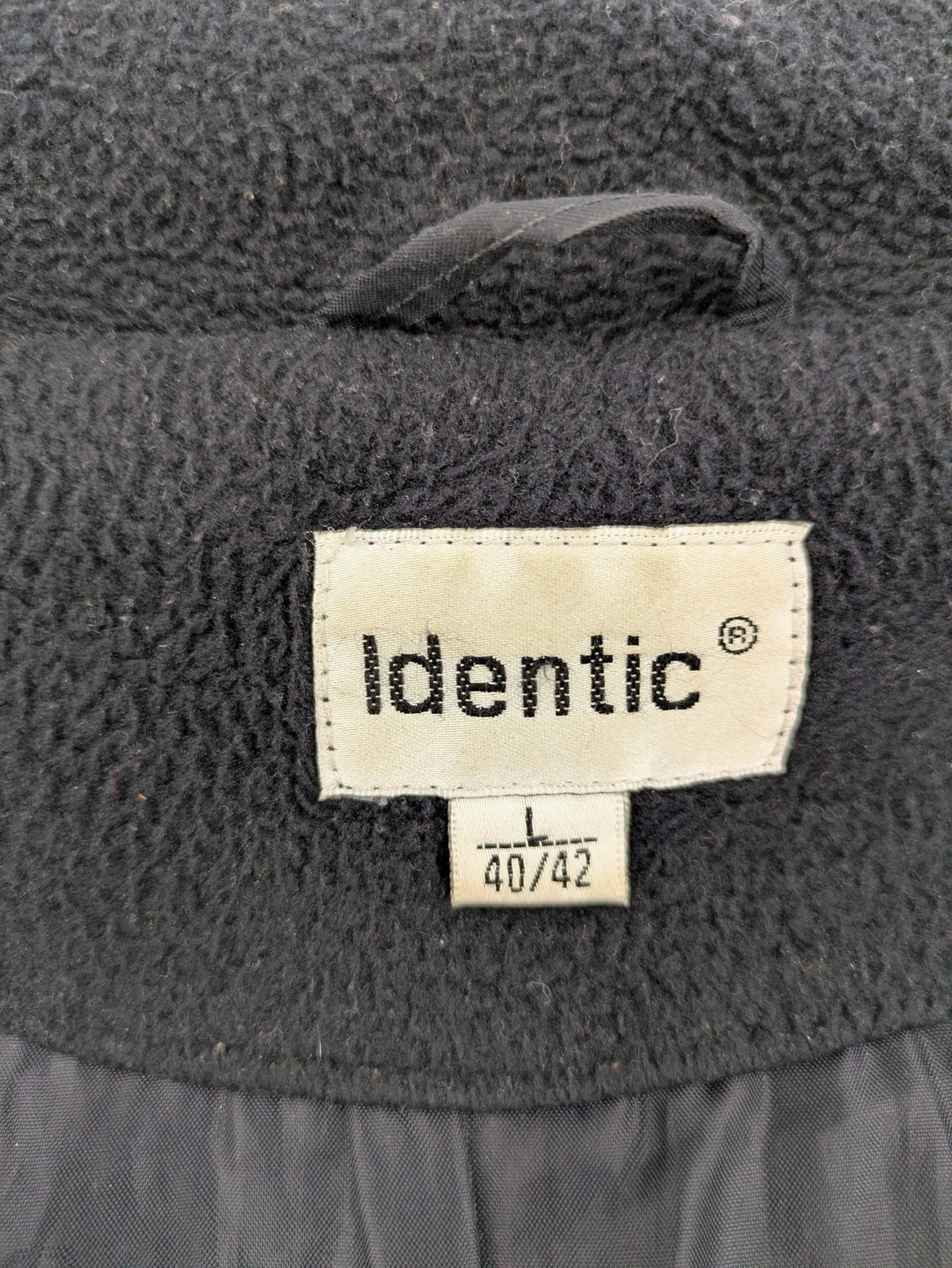 Identic black puffer jacket with quilted design and fleece-lined high collar.