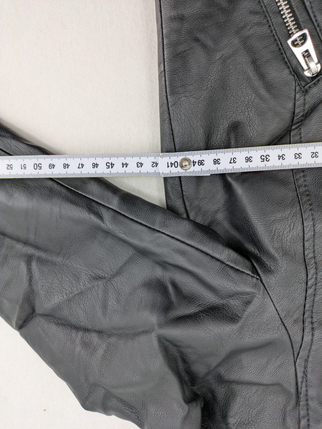 H&M black biker jacket with silver zippers, shoulder flaps, and snap-button details.