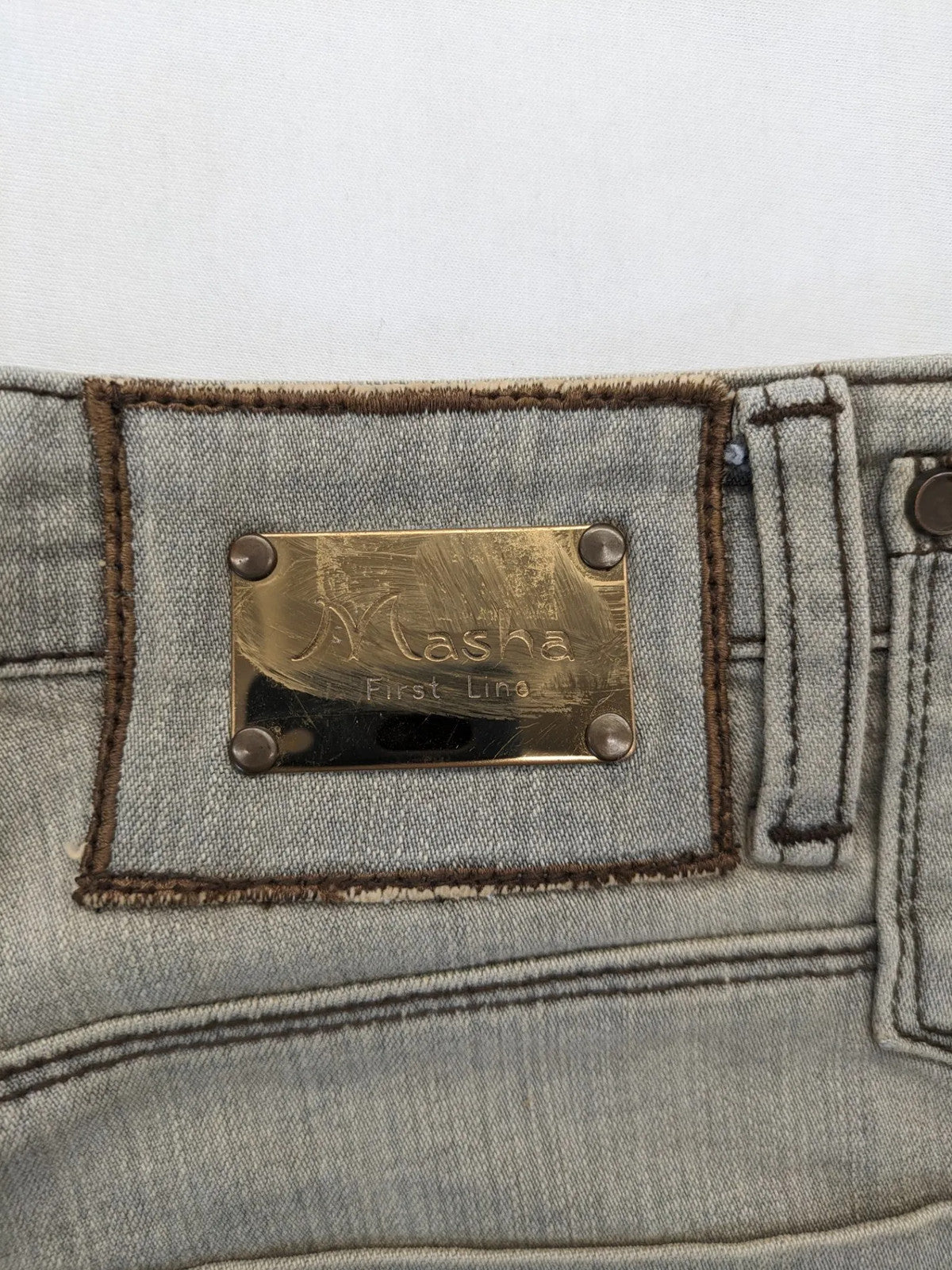 Masha khaki straight jeans with rhinestone embellishments and decorative stitching.