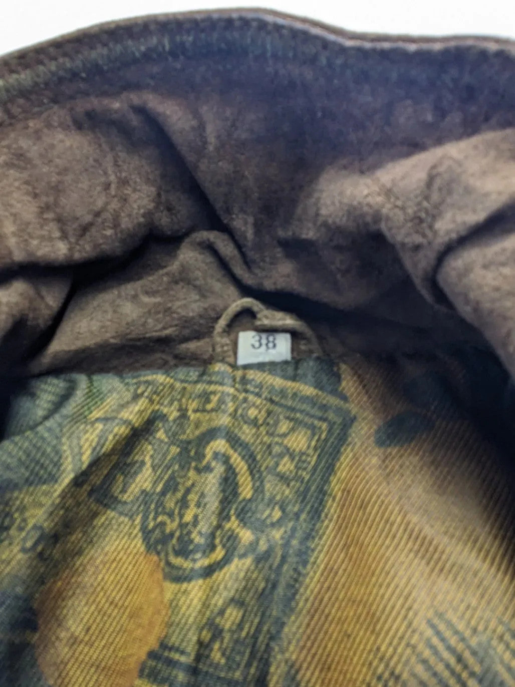 Vintage brown leather jacket with graphic lining, zip closure, and button placket.