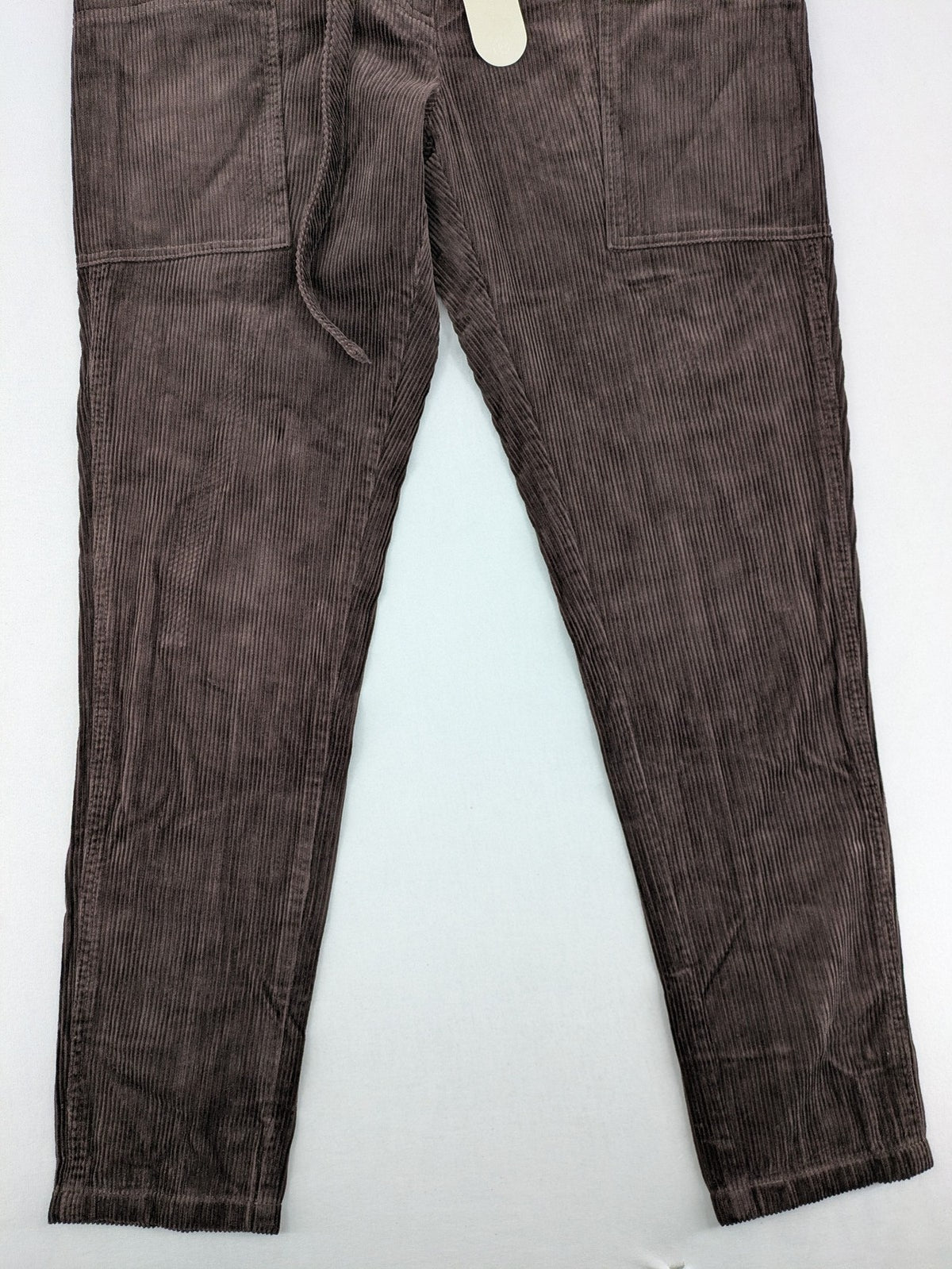 Alma & Lovis brown cord pants with elastic waistband, drawstring, and front patch pockets.