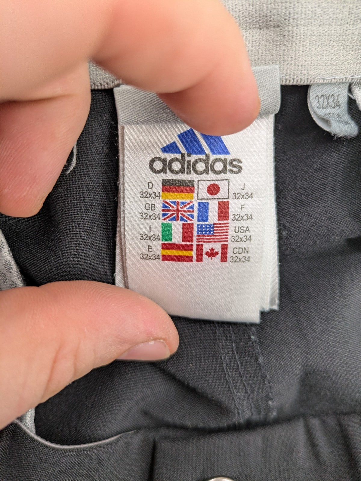 Adidas grey pants with 3-stripe logo, flat-front design, made from performance material.
