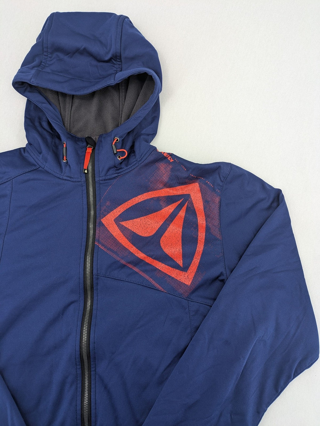 Firefly blue softshell jacket with adjustable hood and prominent chest logo.