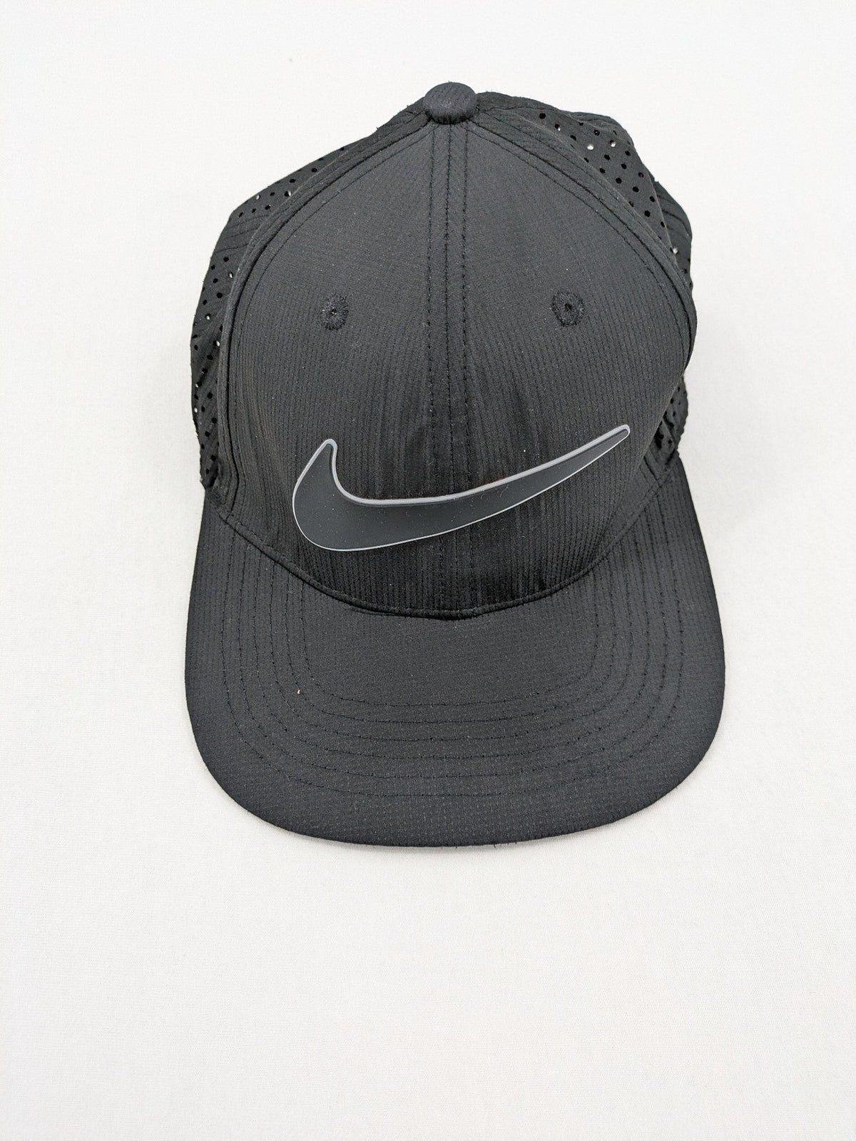 Nike Heritage86 black snapback cap with perforated design and prominent Swoosh logo.