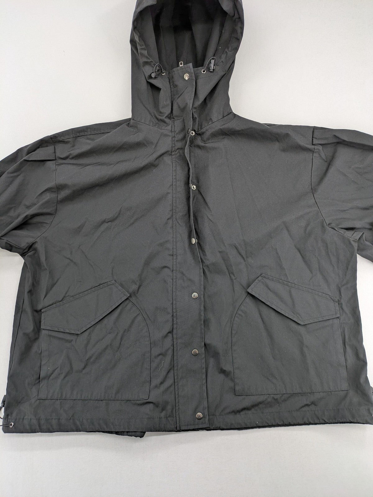 Hypnotism grey windbreaker jacket with hood, snap buttons, and zip closure.