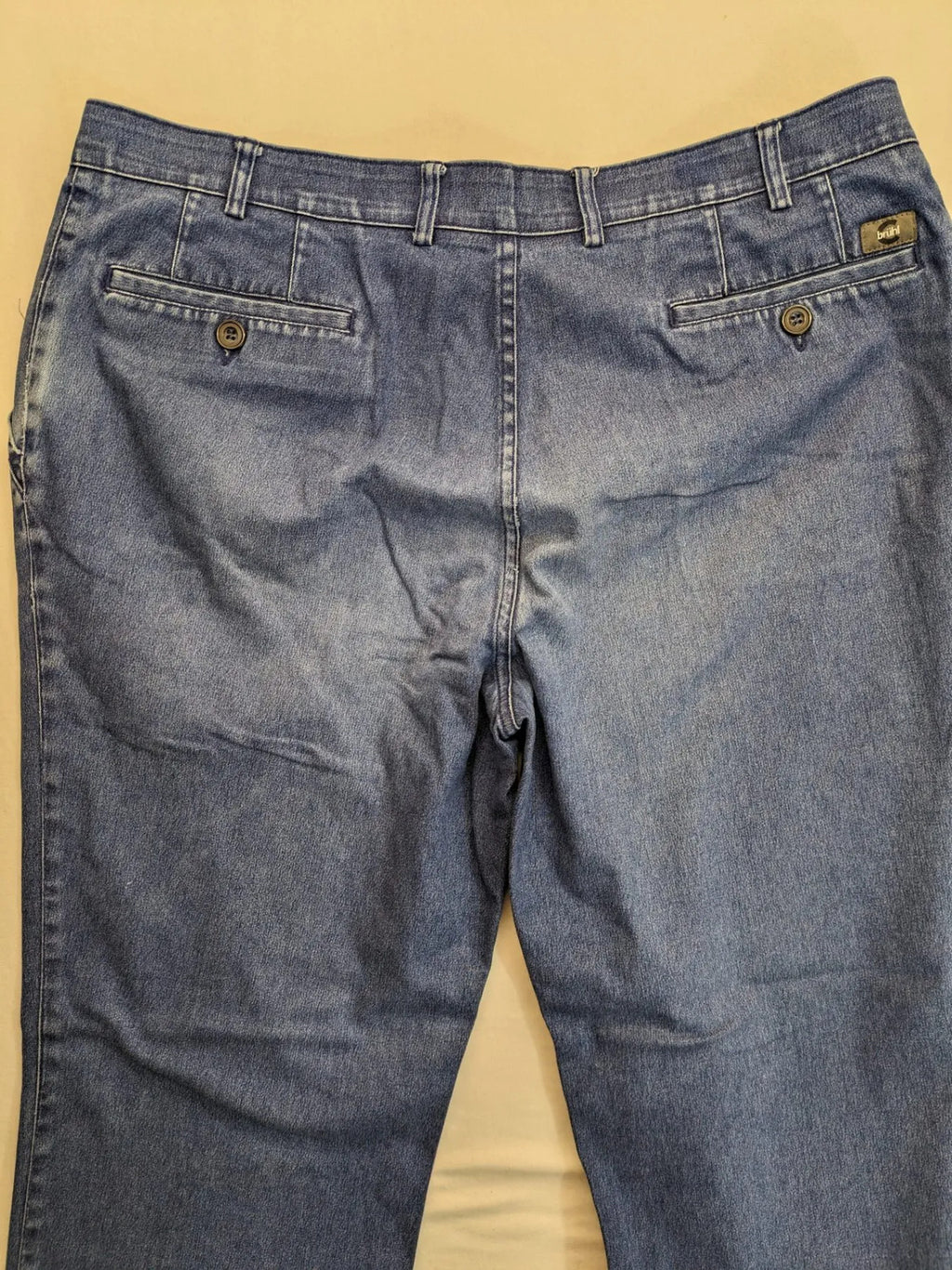 REI blue straight jeans with front pleats, zip fly, and buttoned back pockets.