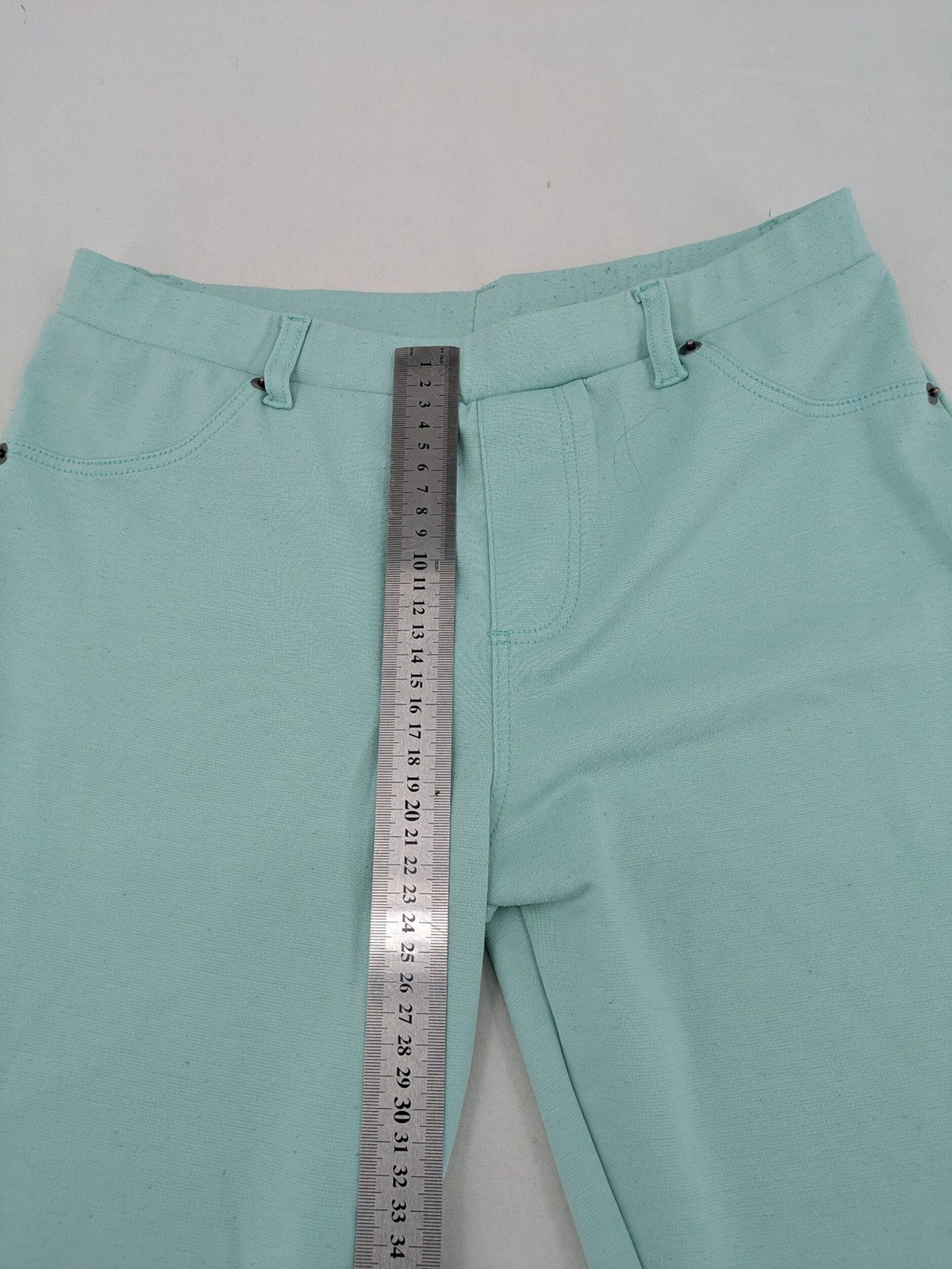 Dito green treggings with pull-on design, front pockets, and belt loops.