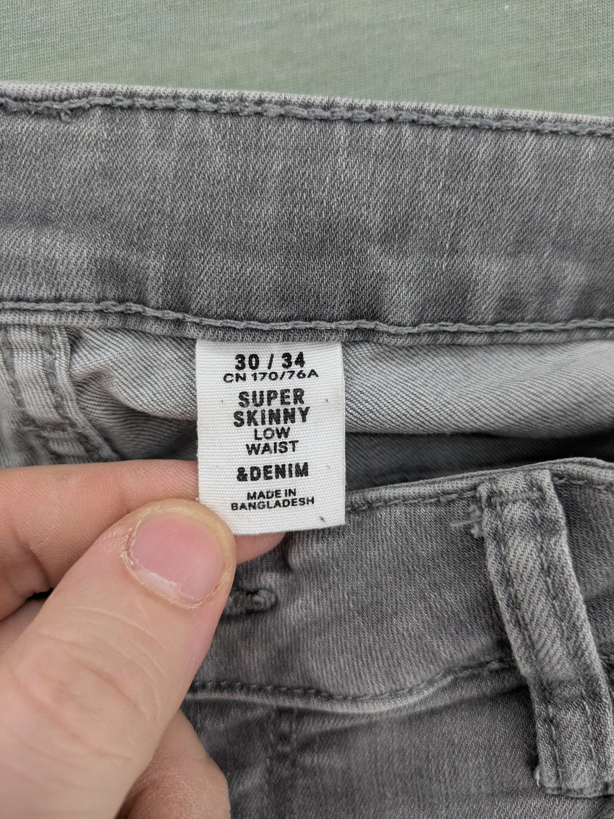 H&M grey super skinny jeans with distressed knee details and low waist fit.