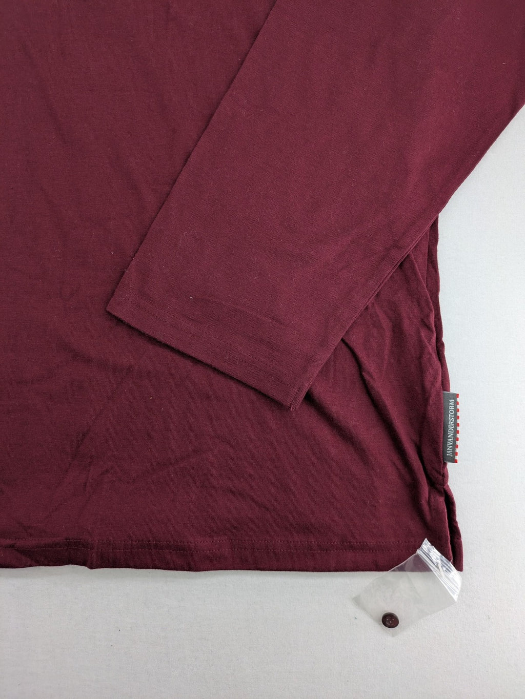 Jan Vanderstorm burgundy Henley shirt with button placket and "087 JV DEPT" graphic print.