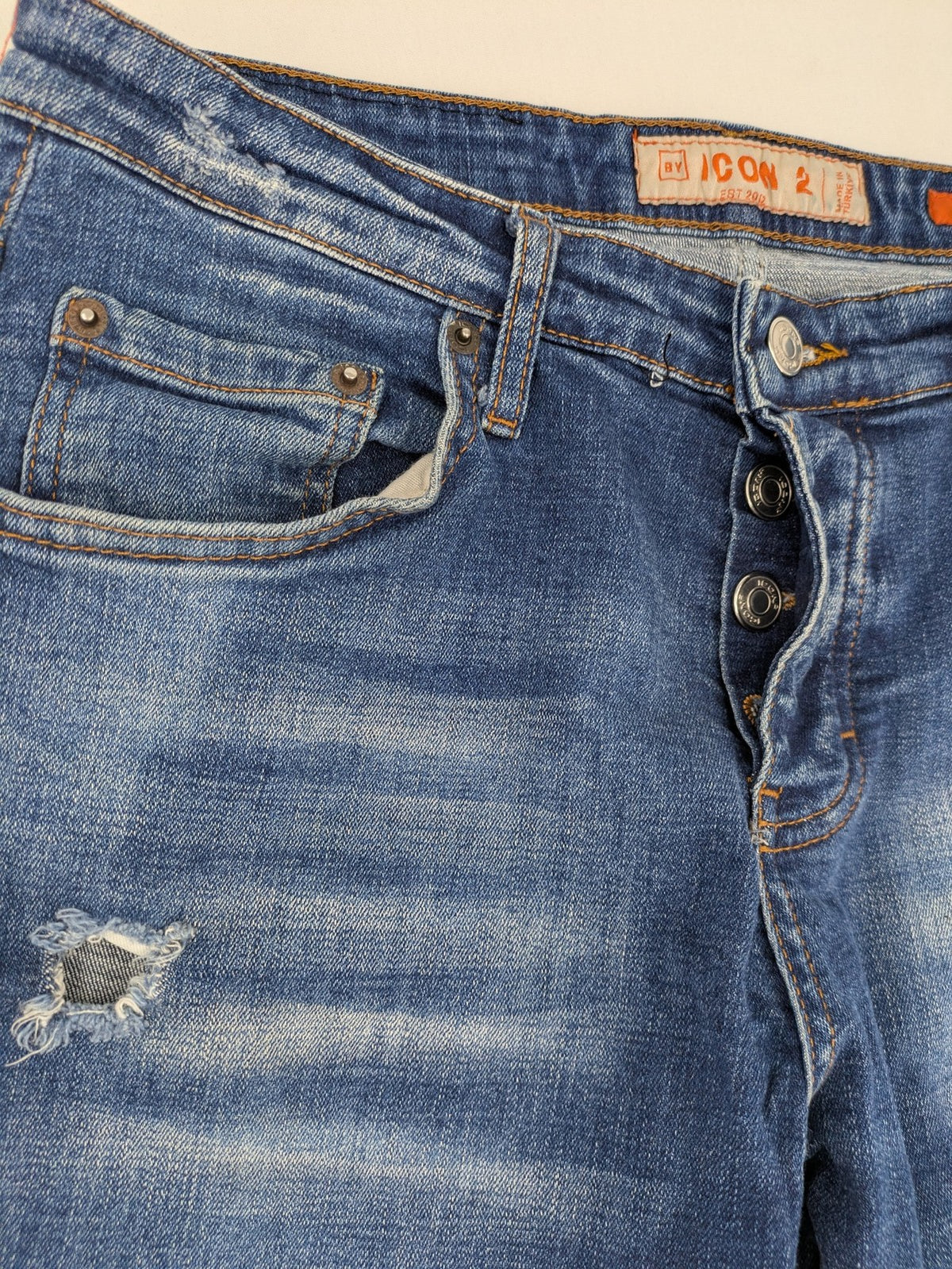 ICON 2 blue slim fit jeans distressed stretch denim with button fly and faded details.