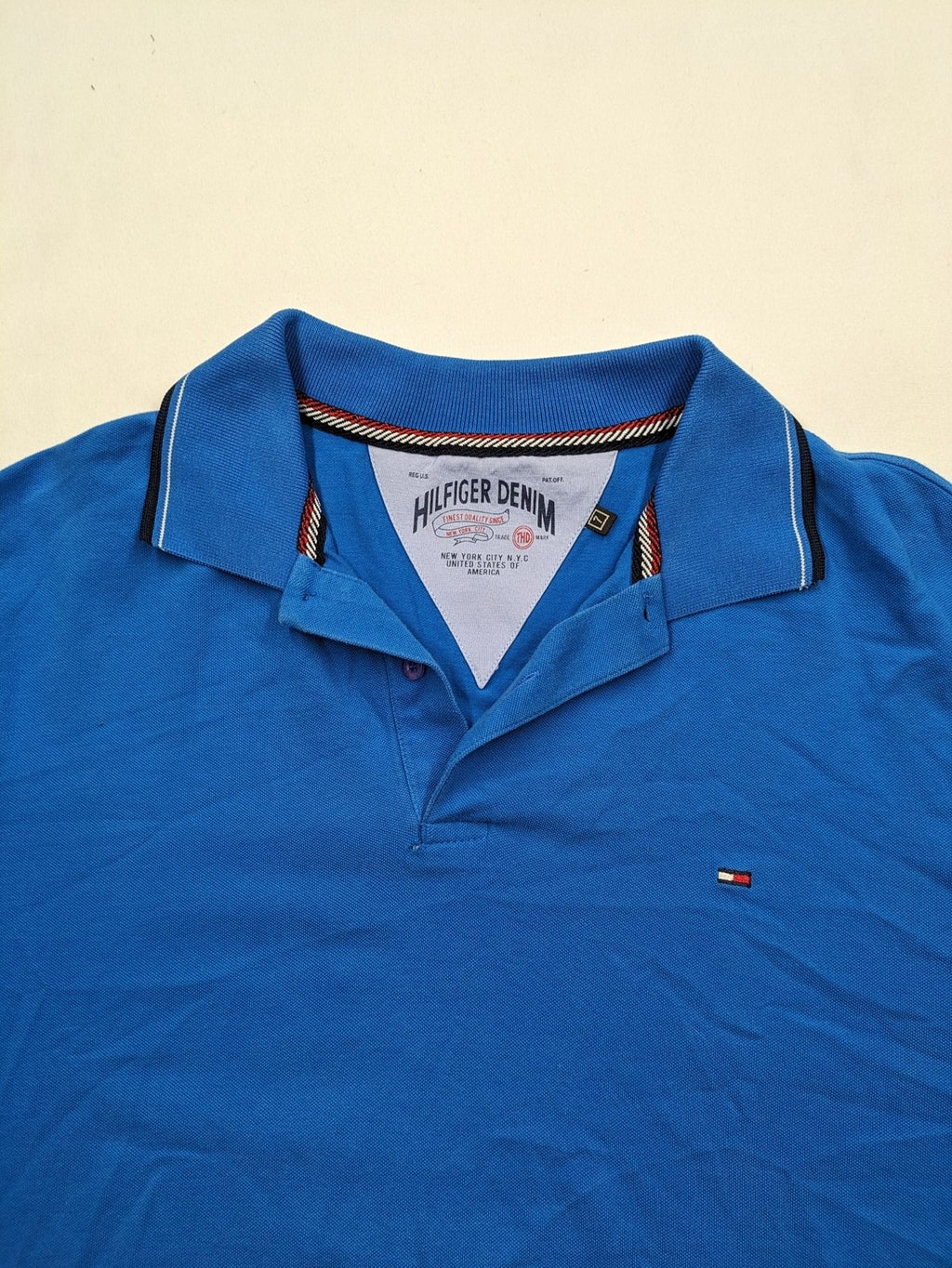 Tommy Hilfiger blue polo shirt with white stripes and embroidered logo on chest.