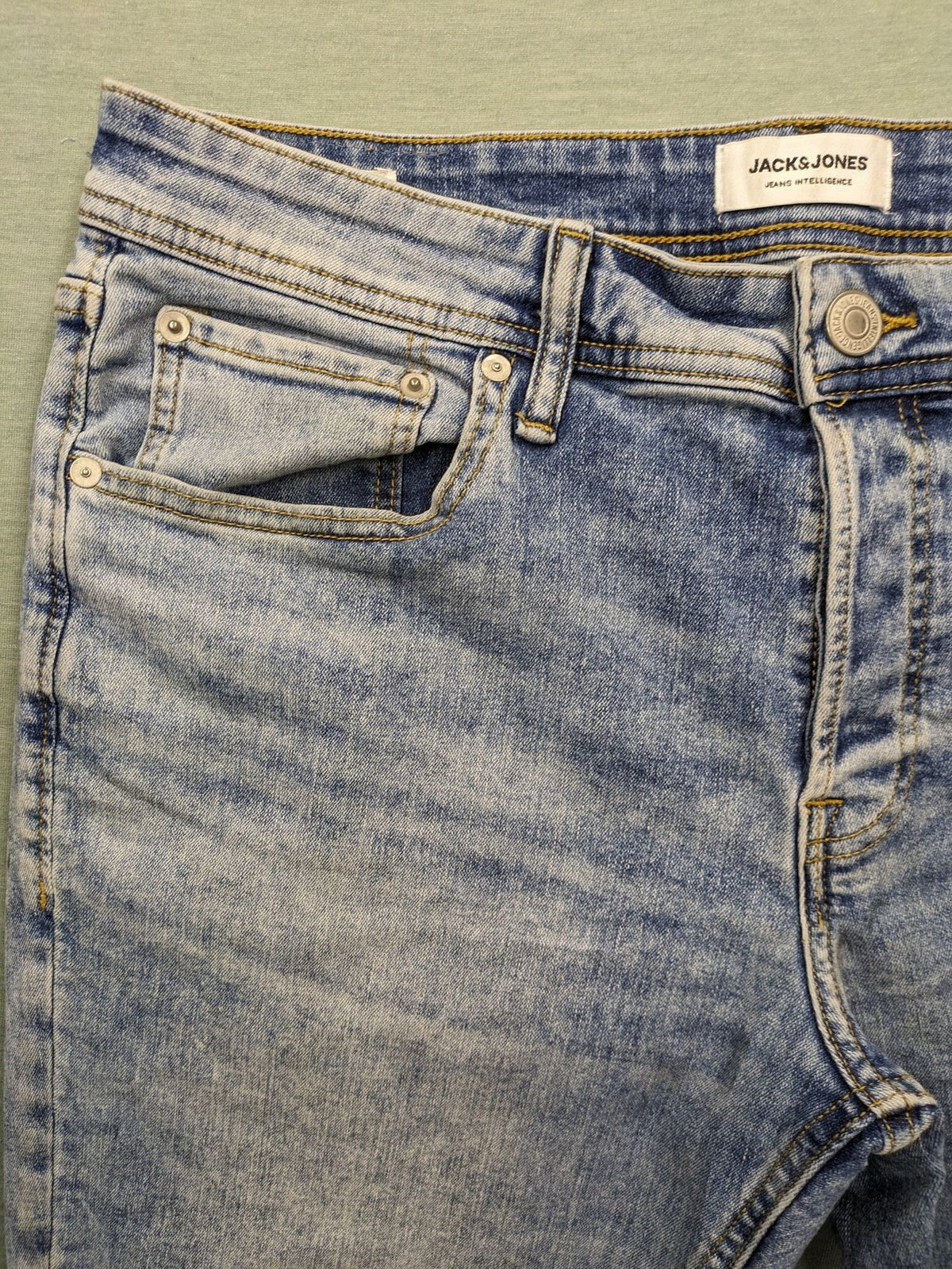 Jack & Jones blue slim fit jeans with button fly and light wash denim texture.