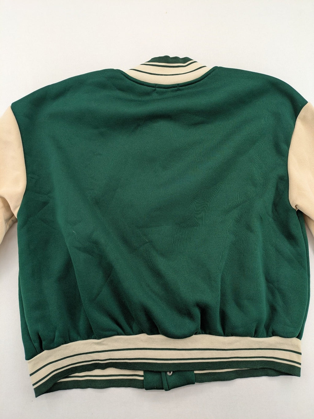 Shein Curve beige bomber jacket with green "Alaska" embroidery and striped ribbed cuffs.
