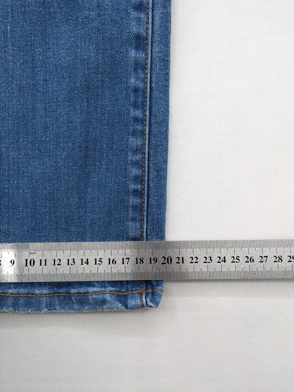 Denim blue straight jeans low rise bootcut with classic 5-pocket design and subtle rivets.