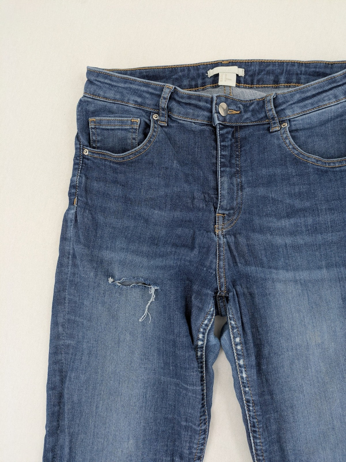 H&M blue skinny jeans with distressed details and comfortable stretch denim material.