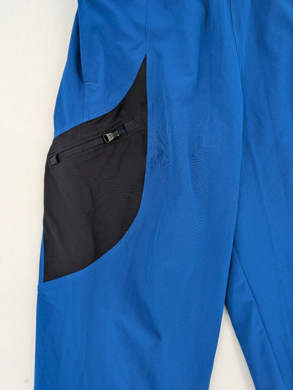 Under Armour blue HeatGear joggers with black accents and zippered cargo pockets.
