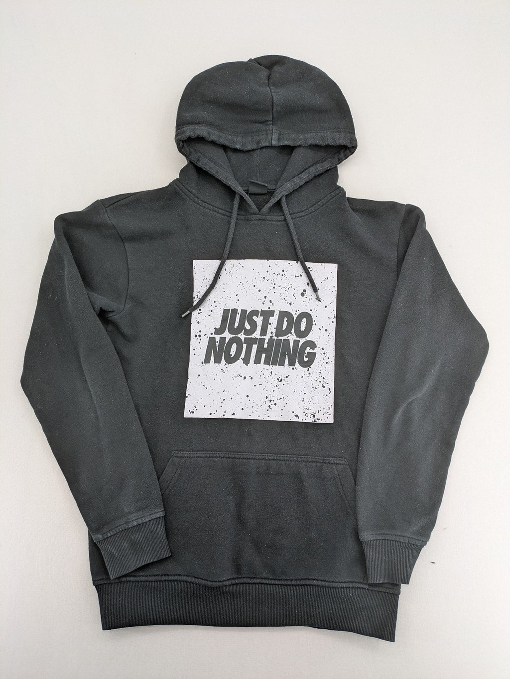 FSBN white zip-through hoodie with "Just Do Nothing" graphic and adjustable drawstring hood.