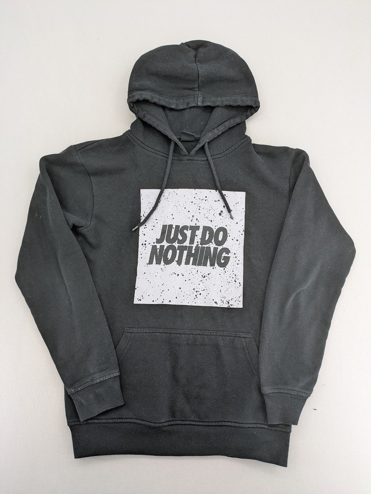FSBN white zip-through hoodie with "Just Do Nothing" graphic and adjustable drawstring hood.