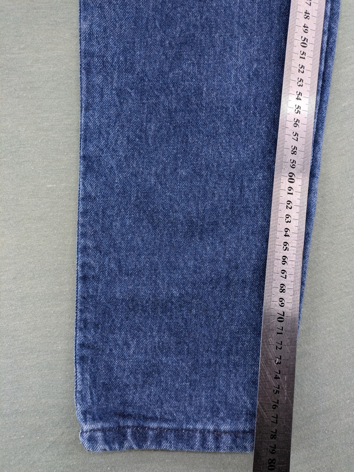 YKK blue high waist mom jeans with decorative front zipper pockets and vintage denim texture.