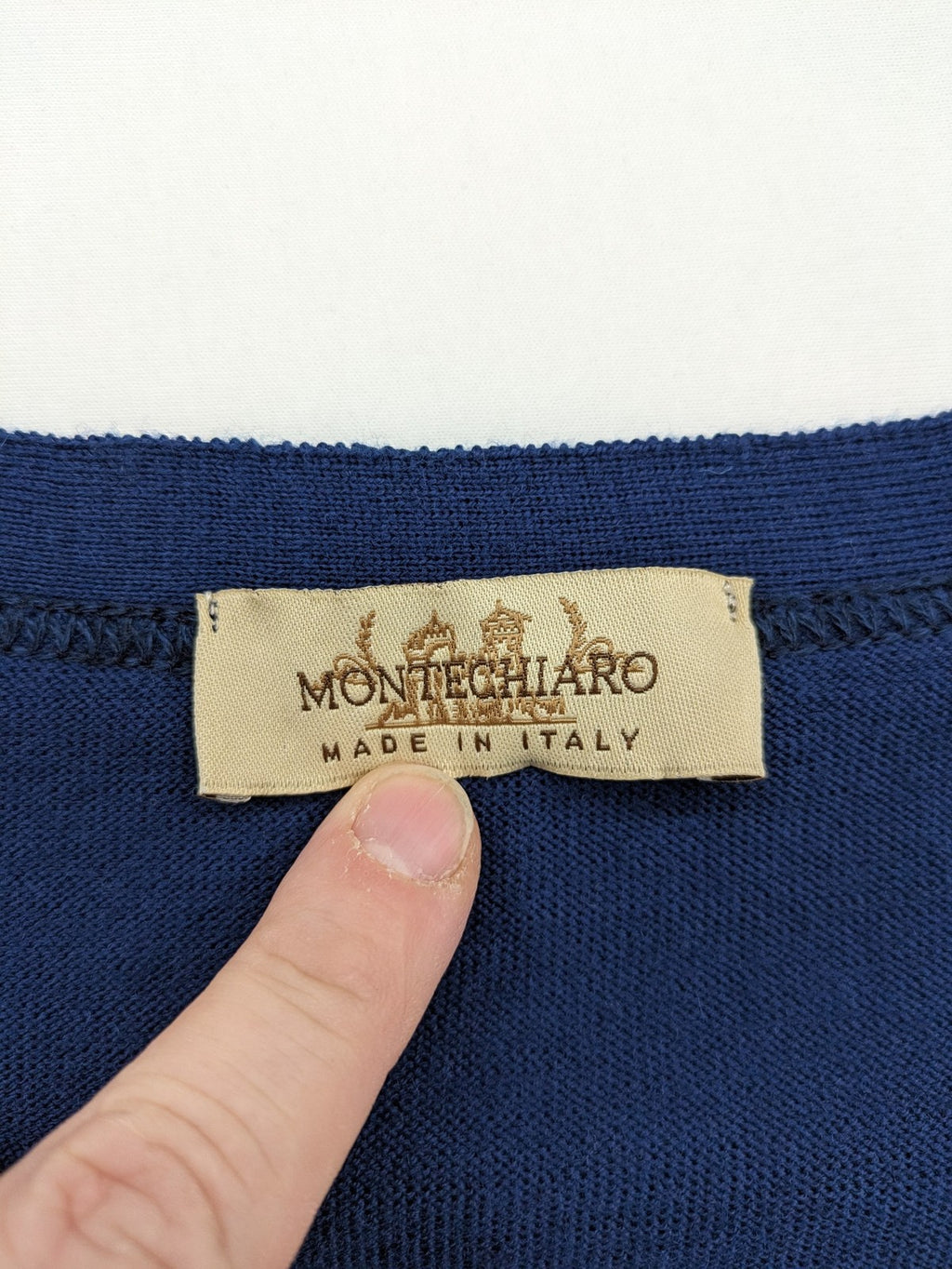 Montechiaro blue turtle neck jumper with V-neck, button placket, and sleeveless design.