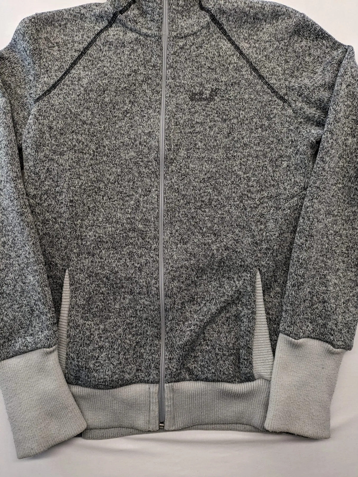 Jack Wolfskin grey fleece jacket with logo detailing and two front pockets.