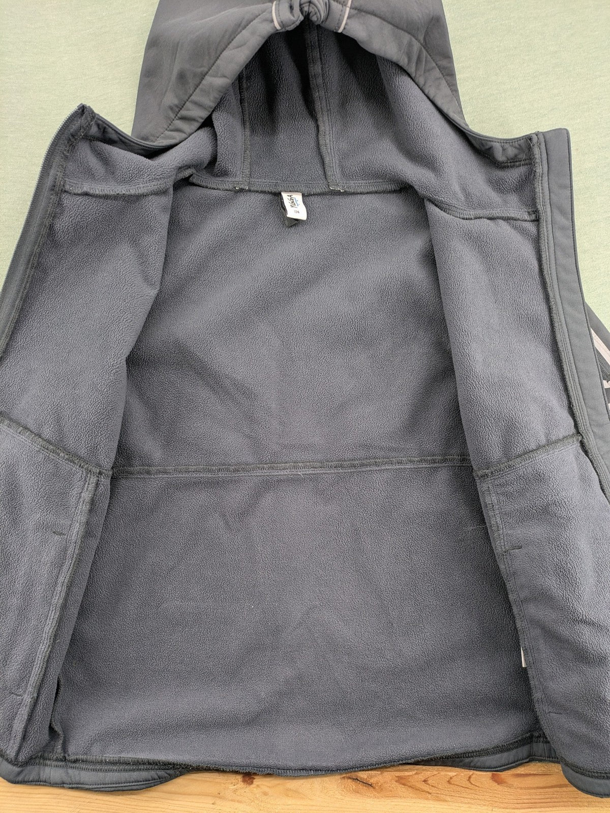Yigga grey softshell coat with fleece lining, hood, and reflective details.