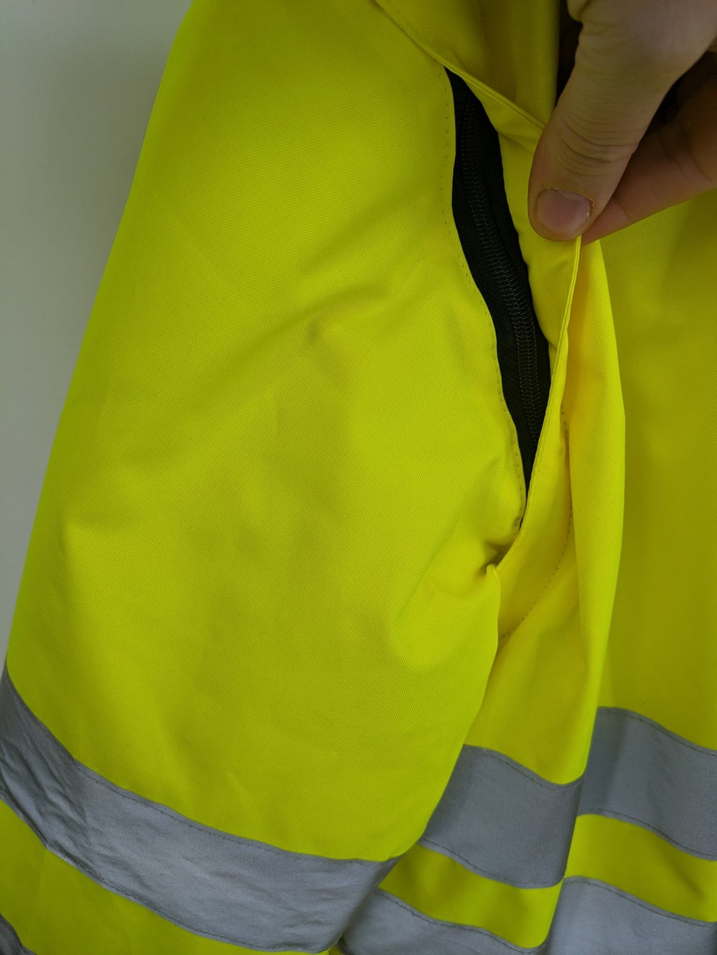 Hüren OHG grey and neon yellow safety jacket with reflective stripes and zippered arm pocket.