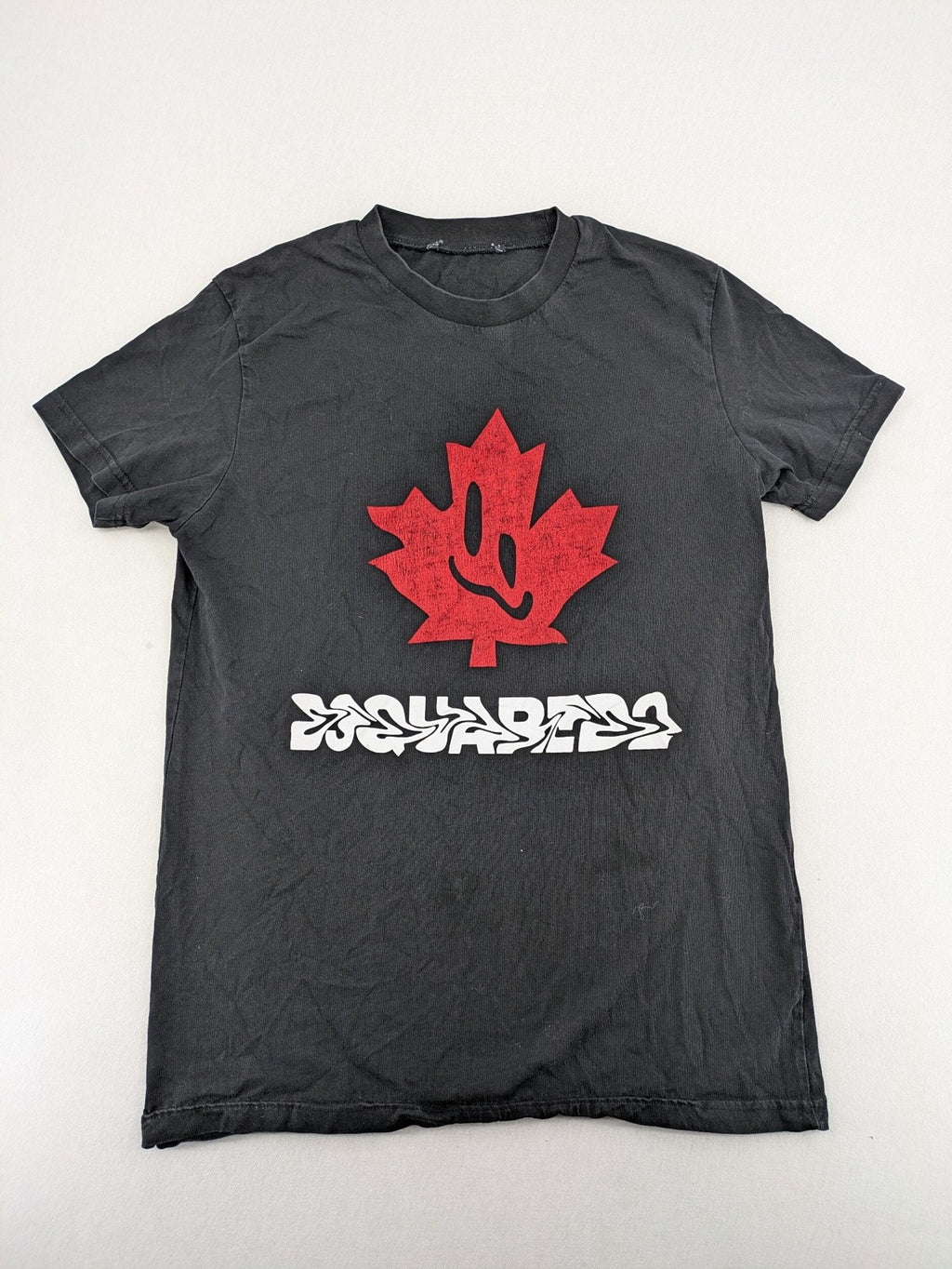 Dsquared2 grey short sleeve shirt with red maple leaf and smiley face graphic.