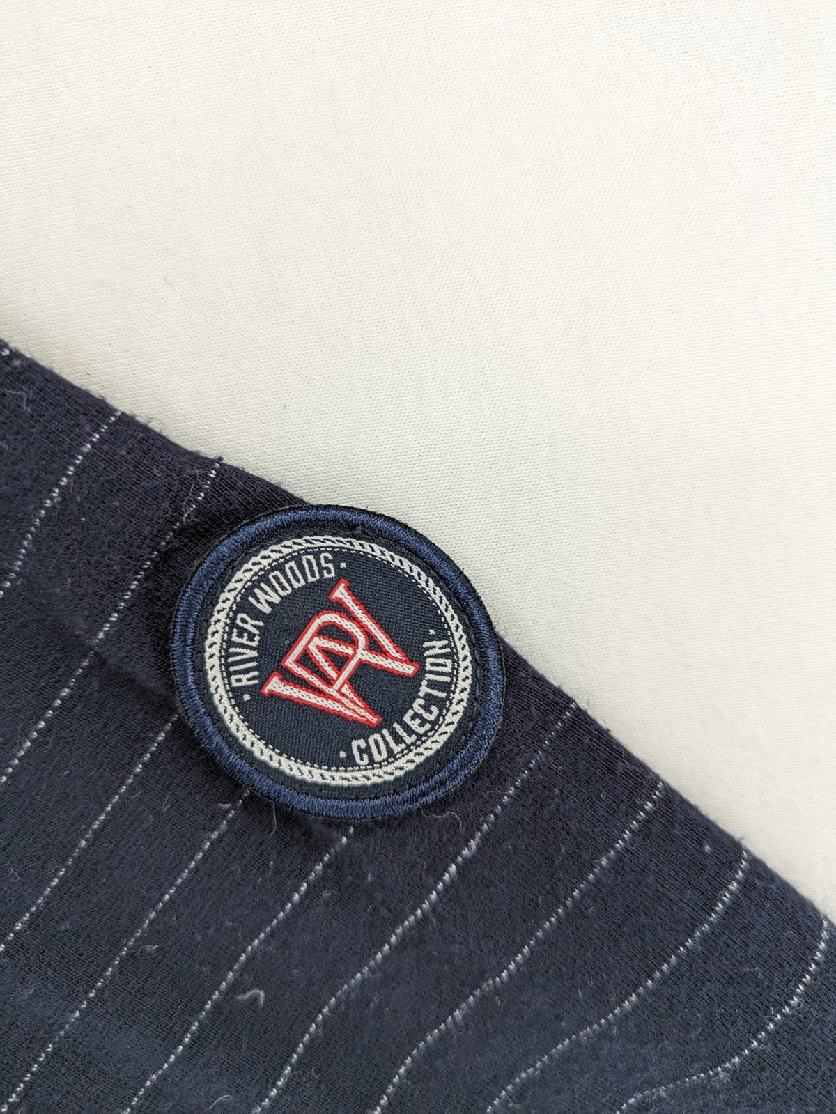 RIVER WOODS navy long sleeve top with white pinstripes and red "I AM très jolie" slogan.