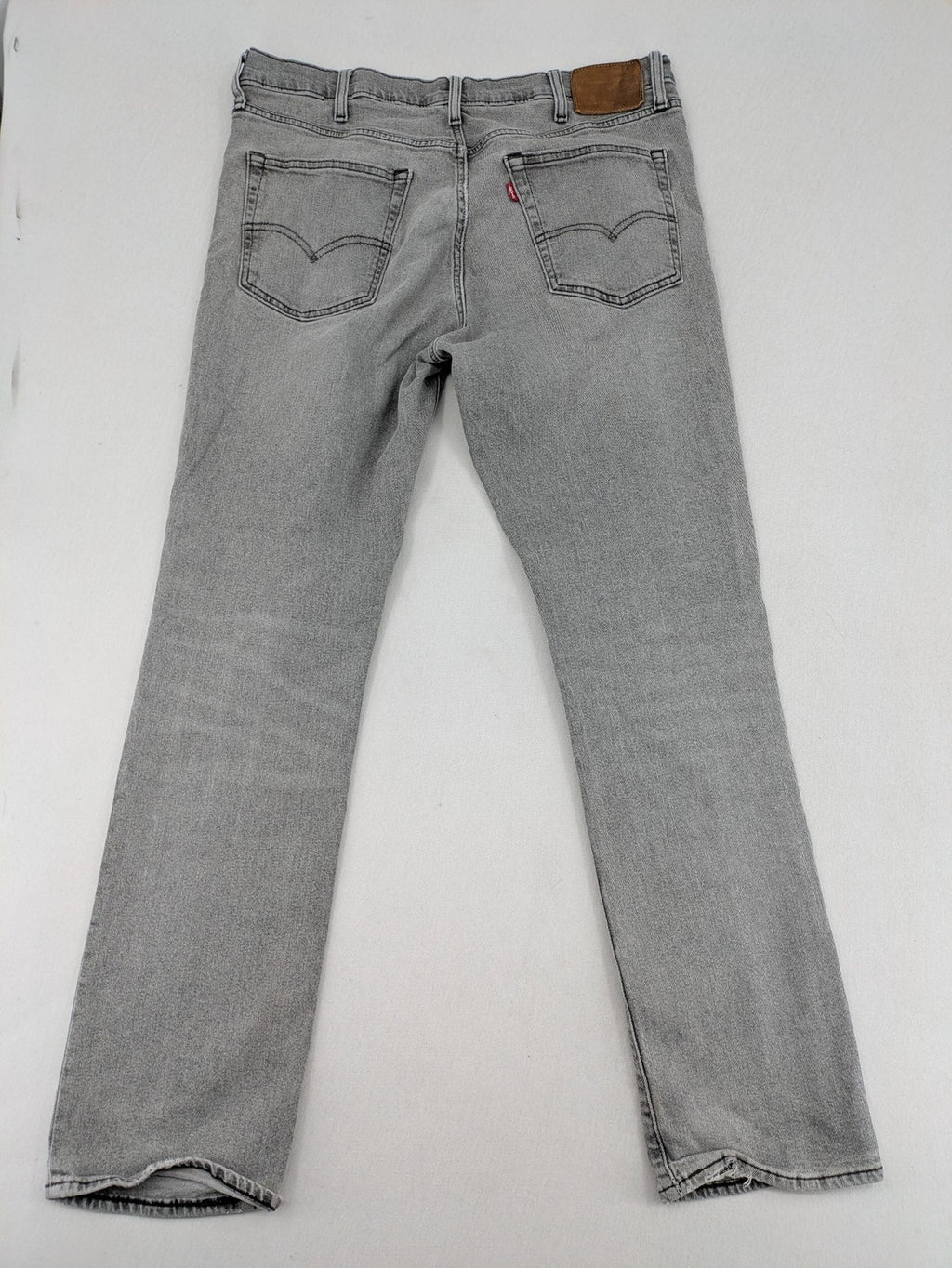 Levi's grey slim fit jeans with distressed knee details and classic logo patch.