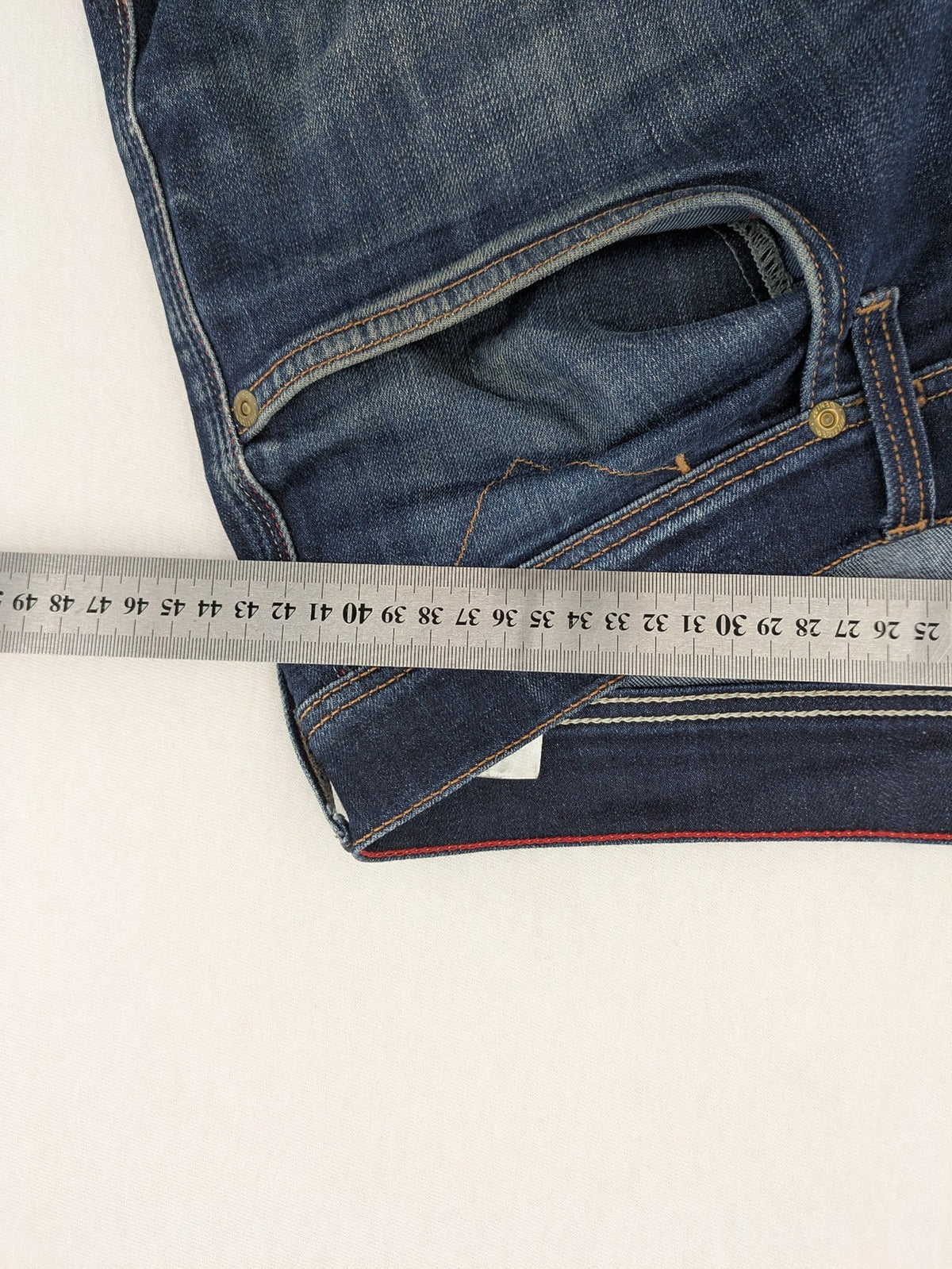 Tommy Hilfiger Denim blue straight jeans with five-pocket design and natural fading details.