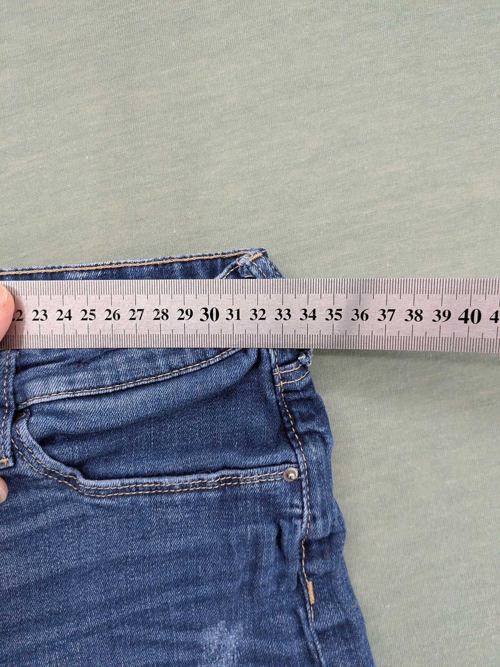 H&M blue skinny jeans with distressed knee details and classic 5-pocket design.